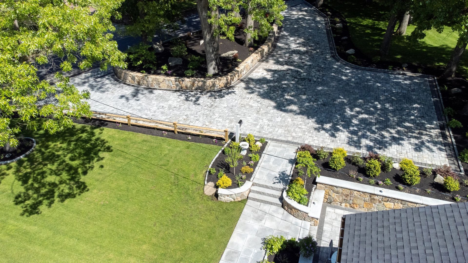 An aerial view of a driveway leading to a house surrounded by trees.