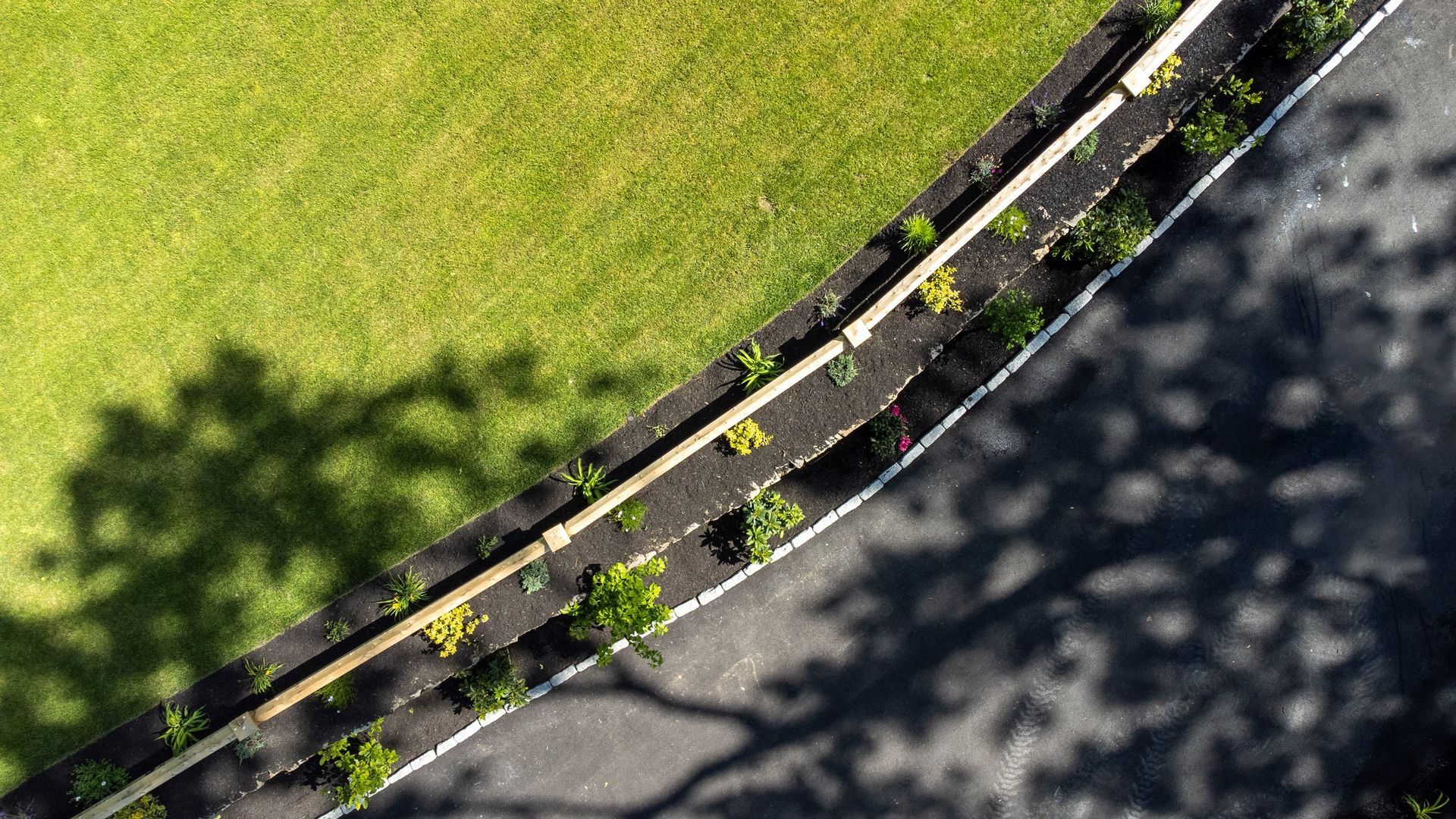 An aerial view of a curvy road surrounded by grass and trees.