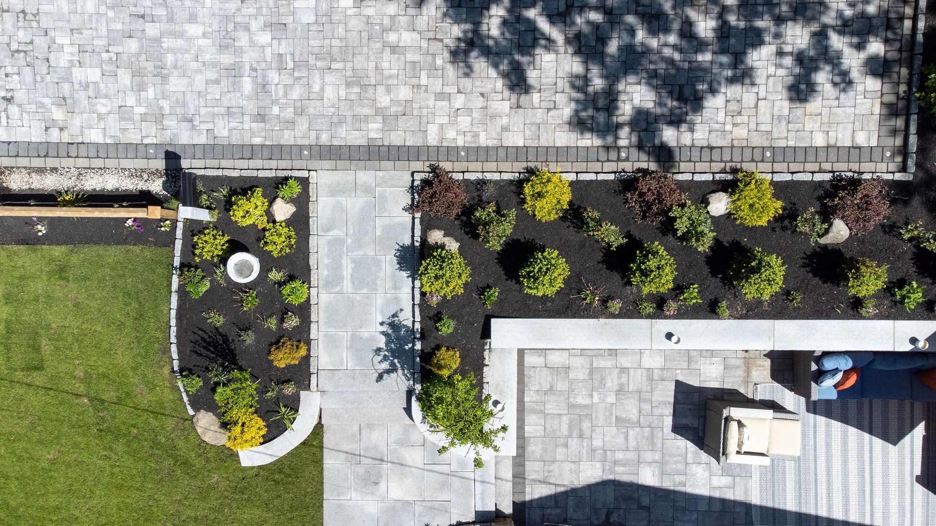 An aerial view of a backyard with a patio and lawn.