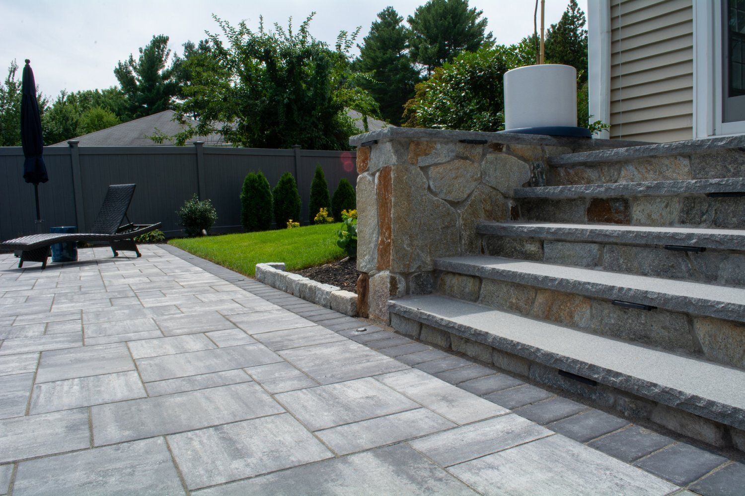 A stone patio with stairs leading up to a house