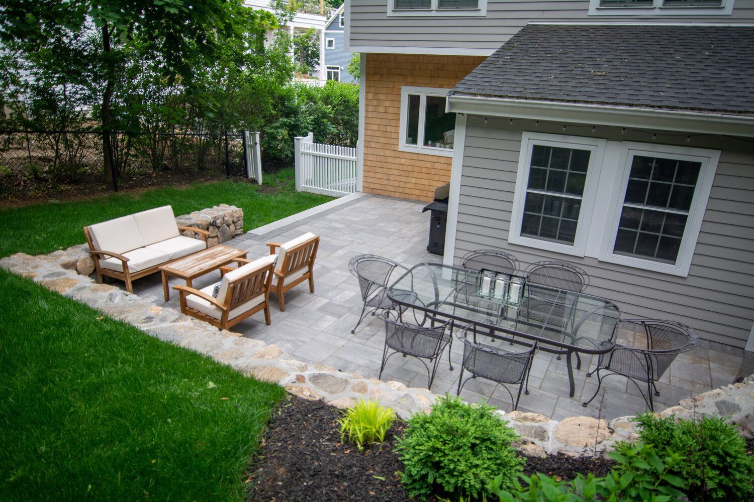 A patio with a table and chairs in front of a house.