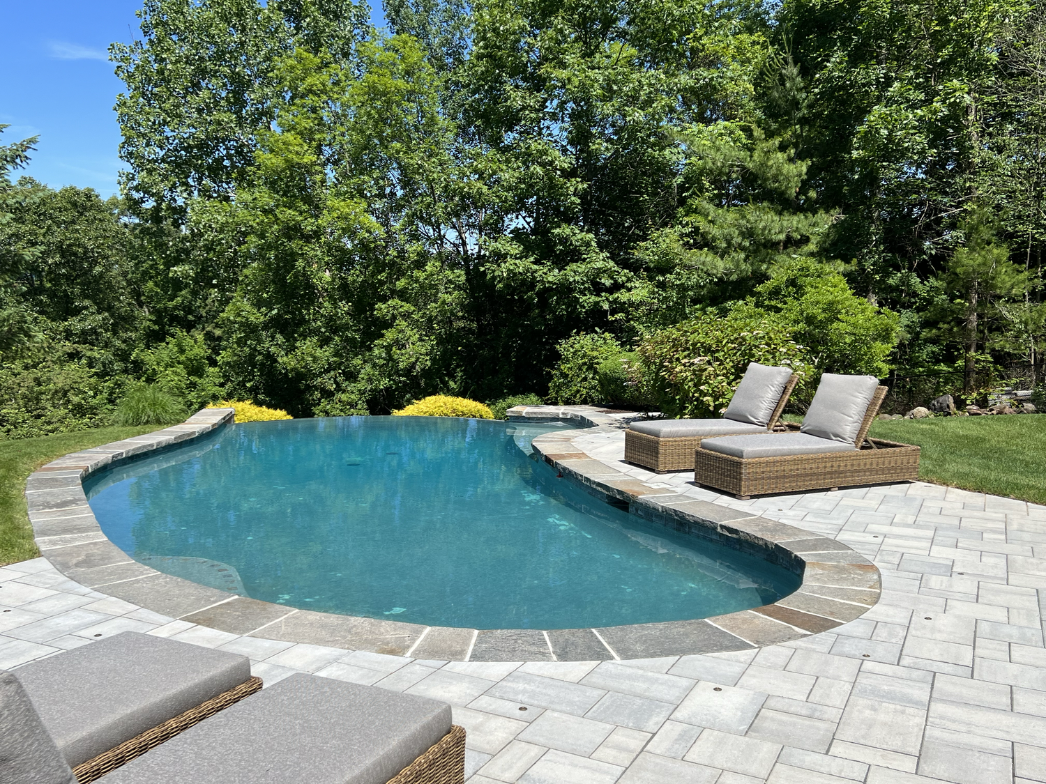 A large swimming pool surrounded by chairs and trees