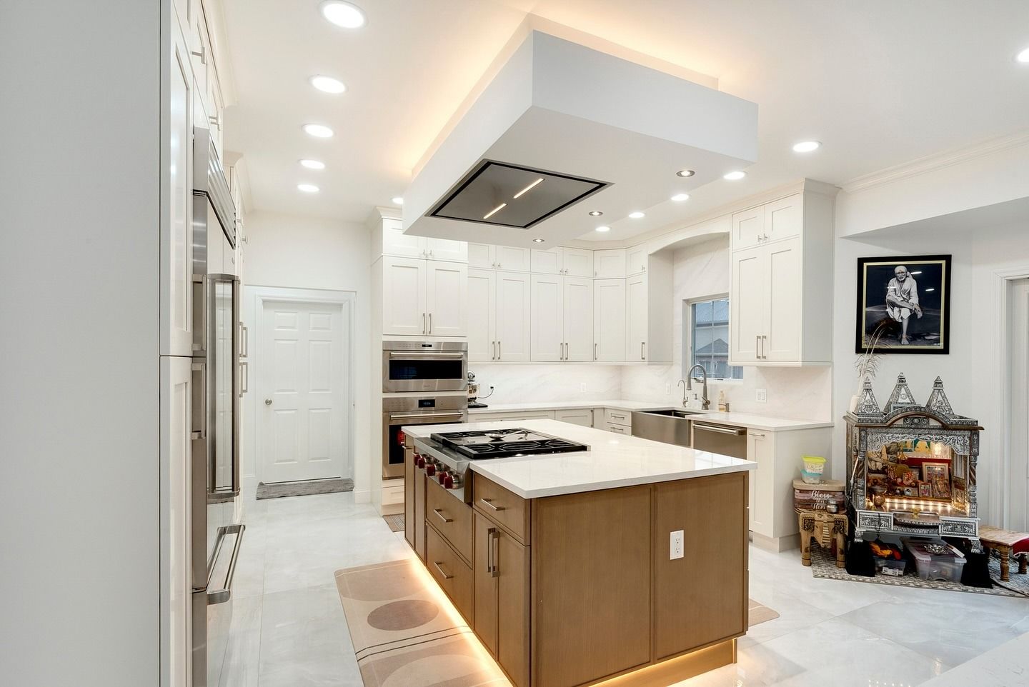 A kitchen with a large island and a stove top oven.