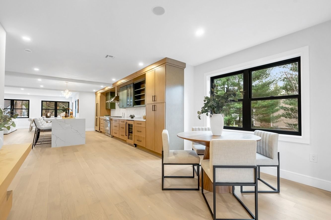 There is a table and chairs in the middle of the room.