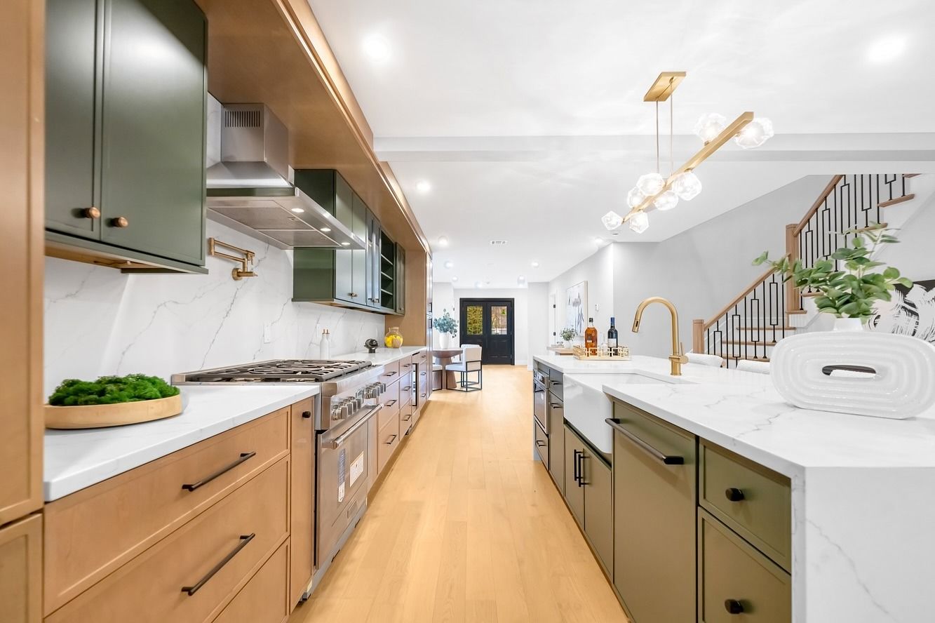 A kitchen with wooden cabinets , white counter tops , and stainless steel appliances.