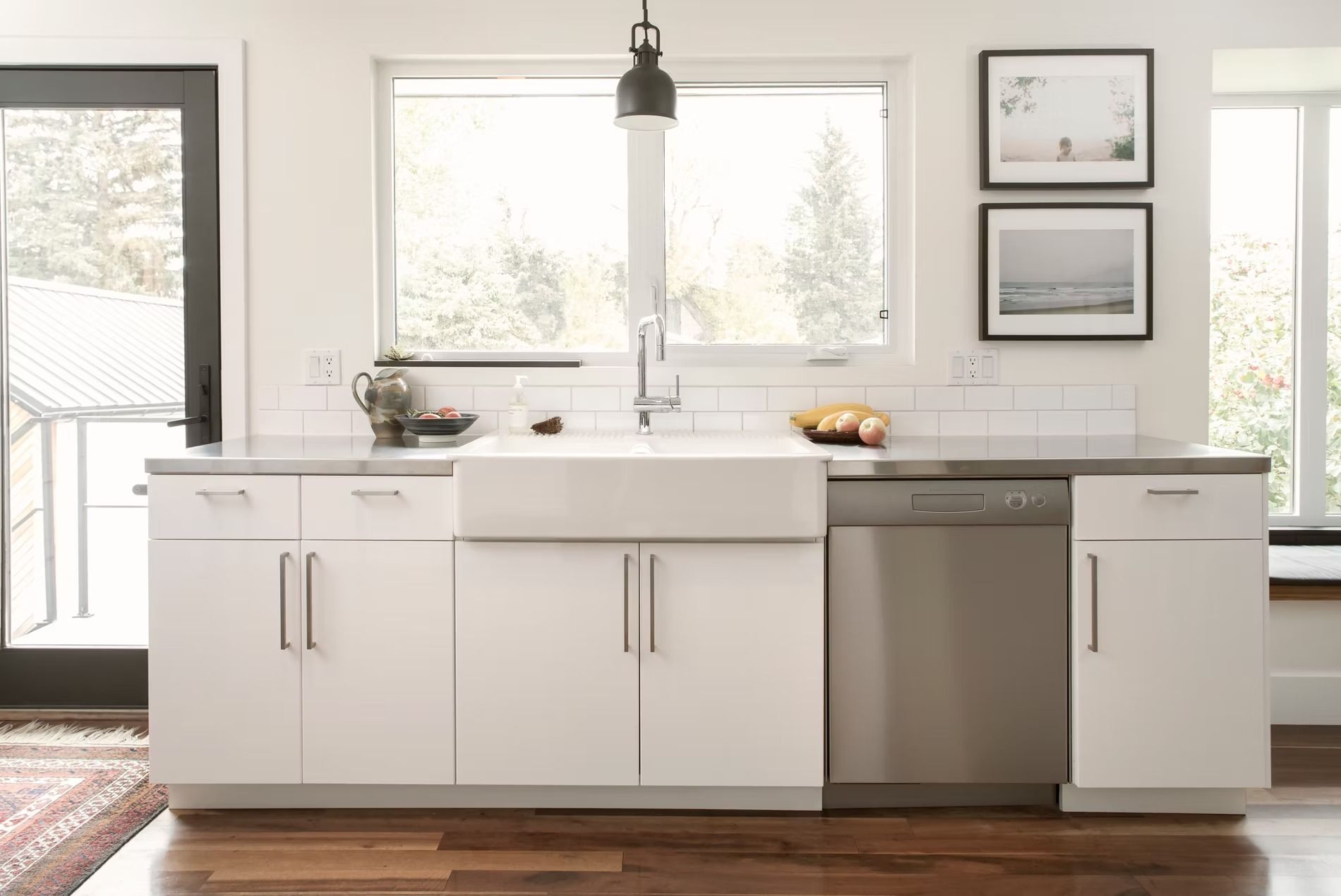 A kitchen with white cabinets and a stainless steel dishwasher.