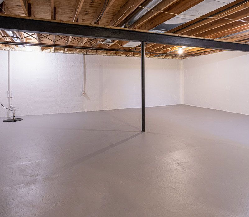 An empty basement with a wooden ceiling and a concrete floor