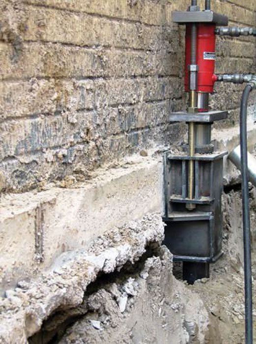 A machine is being used to drill a hole in a brick wall