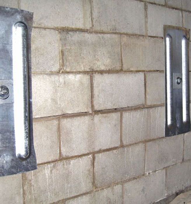 Two lights are mounted to a brick foundation wall