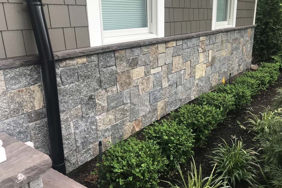 The side of a house with a stone wall
