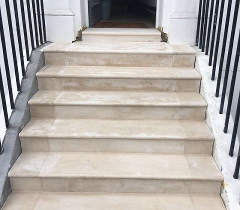 Stairs leading up to a doorway with a black railing