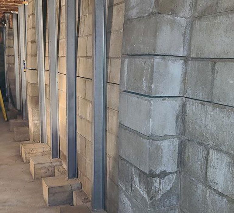 A row of brick walls with metal beams under construction