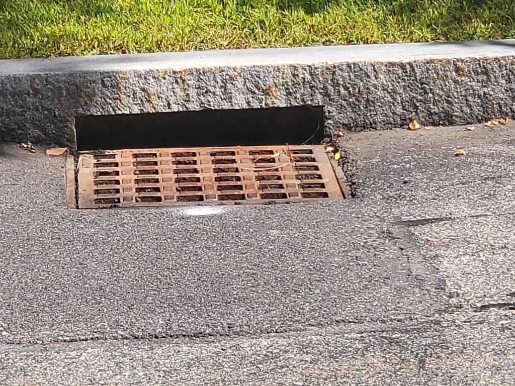 A manhole cover is sitting on the side of a road.