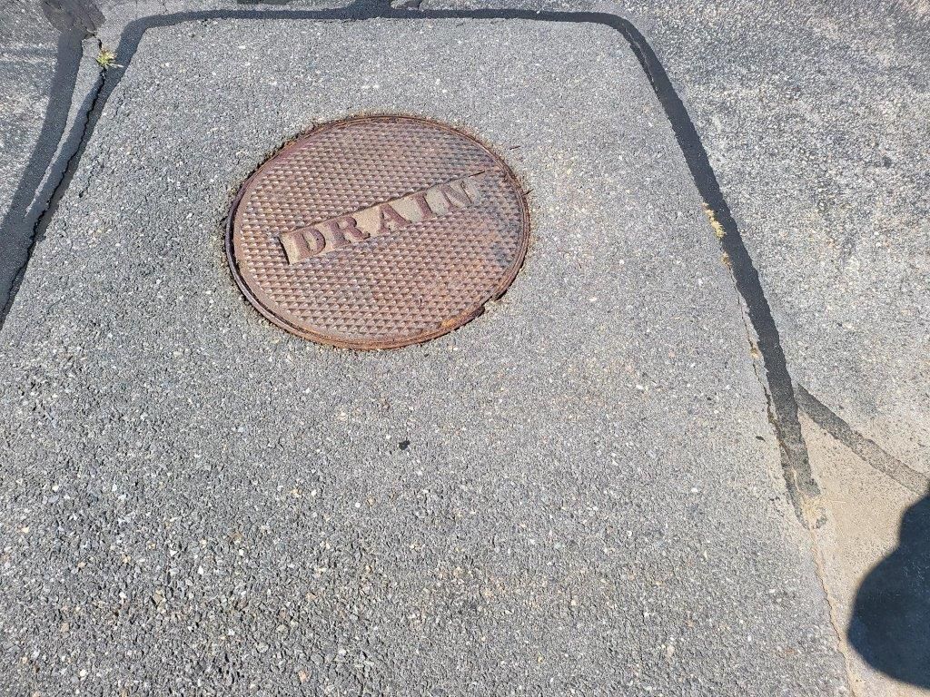 A manhole cover on the side of a road.
