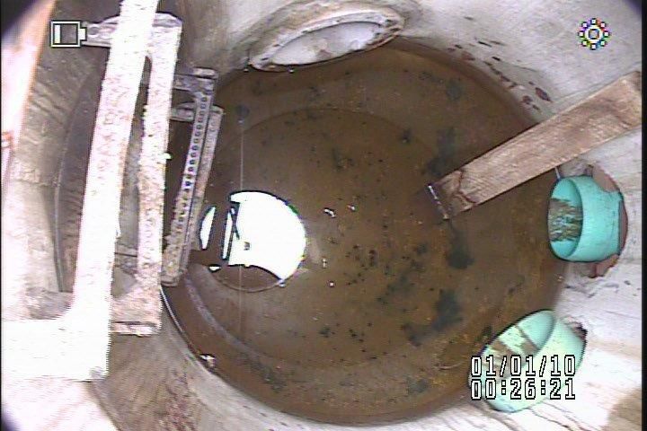 A manhole cover with a hole in the middle of it filled with water.