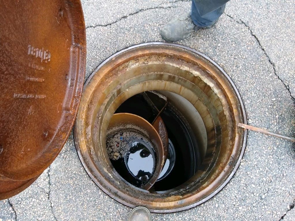 A manhole cover on the ground with a hole in it.