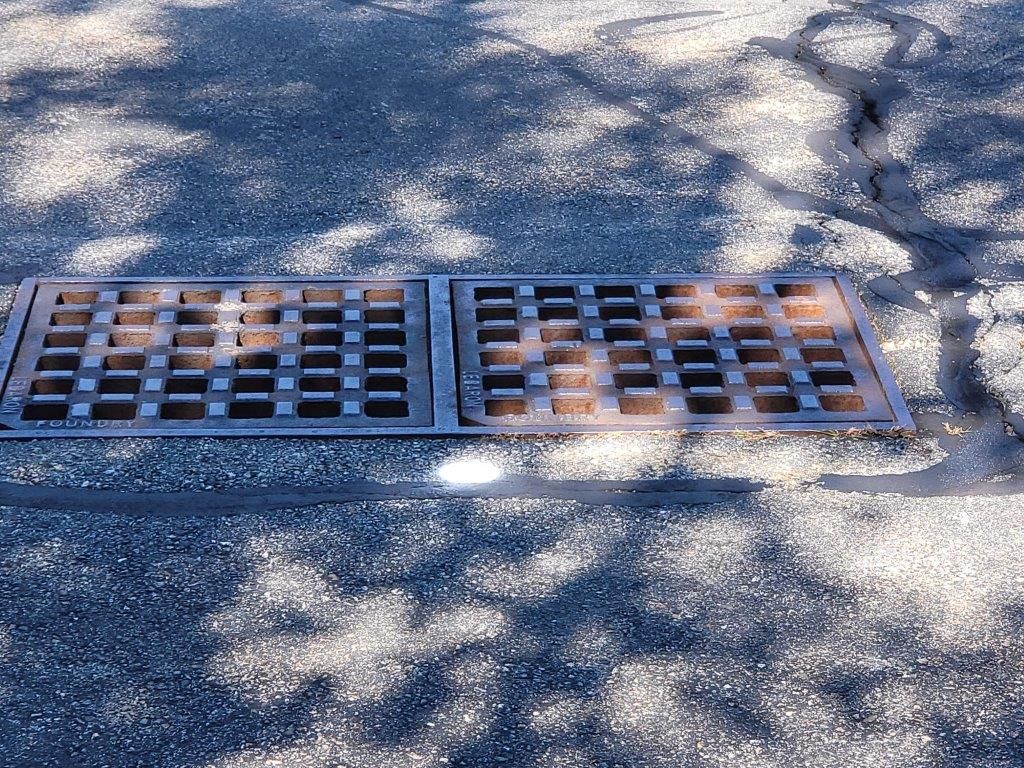 A manhole cover is sitting on the side of the road.
