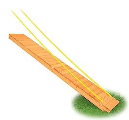 Wooden ramp with yellow ropes, set on grass.