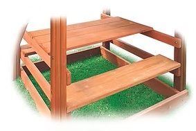 Wooden picnic table with attached bench, set in grass.