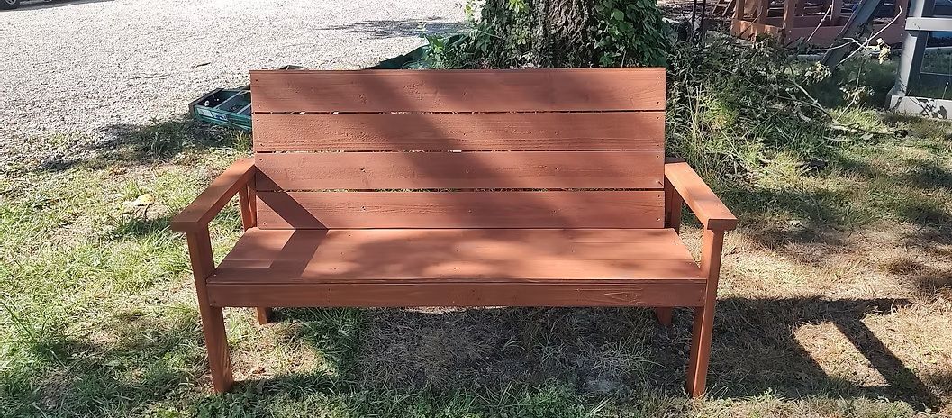 Wooden park bench in a grassy setting.