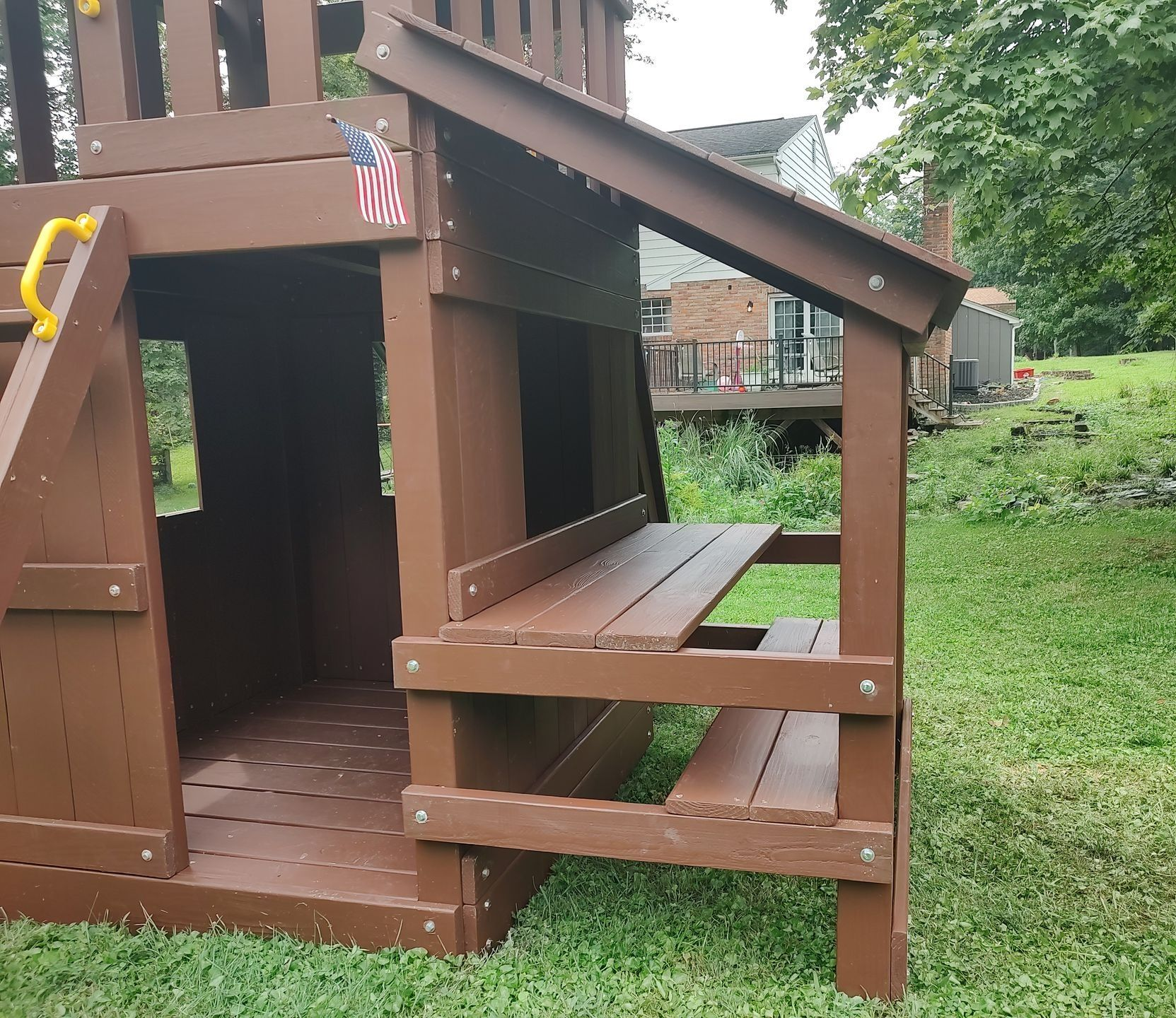 Wooden playhouse with a covered side table