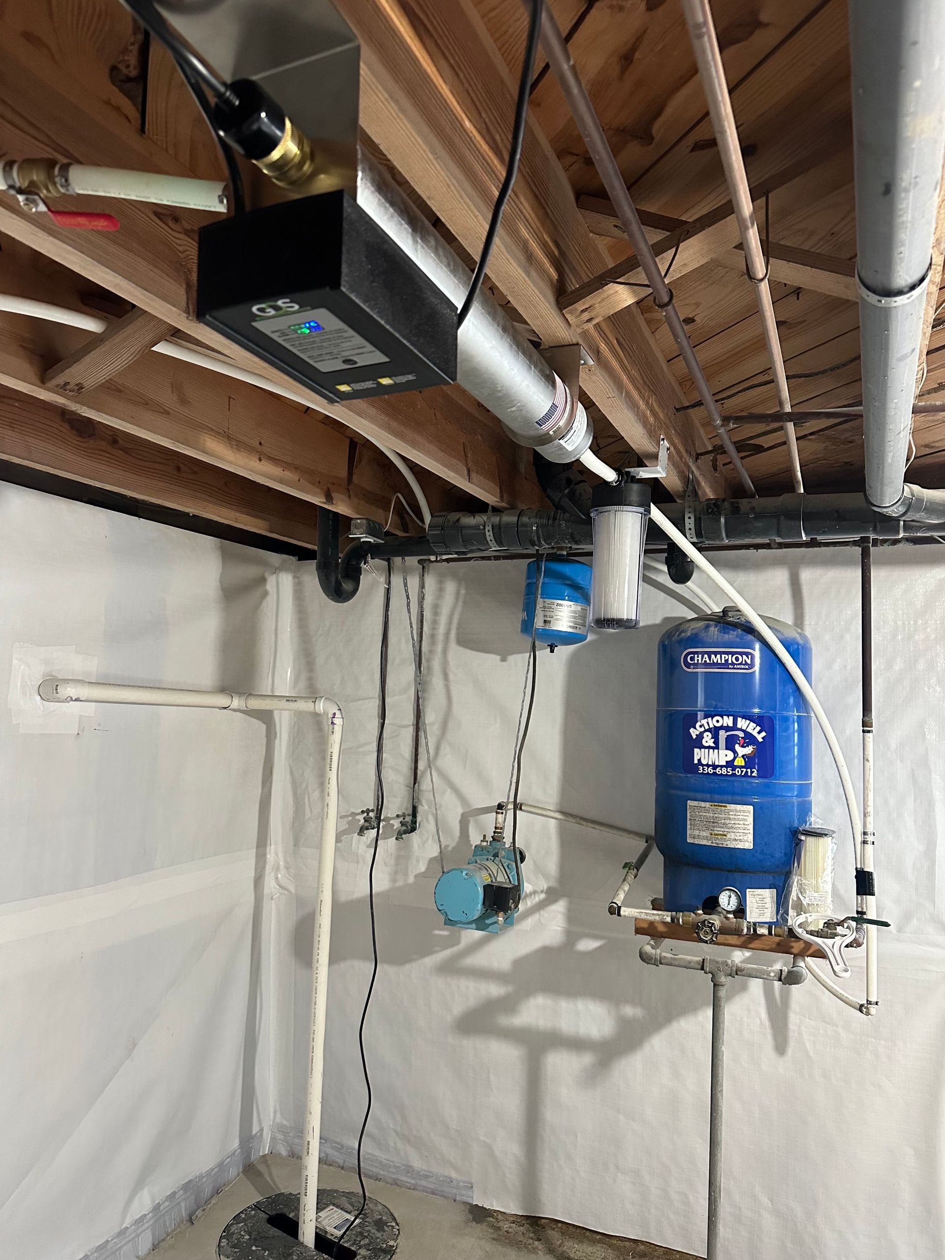 Basement utility area with a blue water heater, furnace, and exposed ceiling pipes and beams