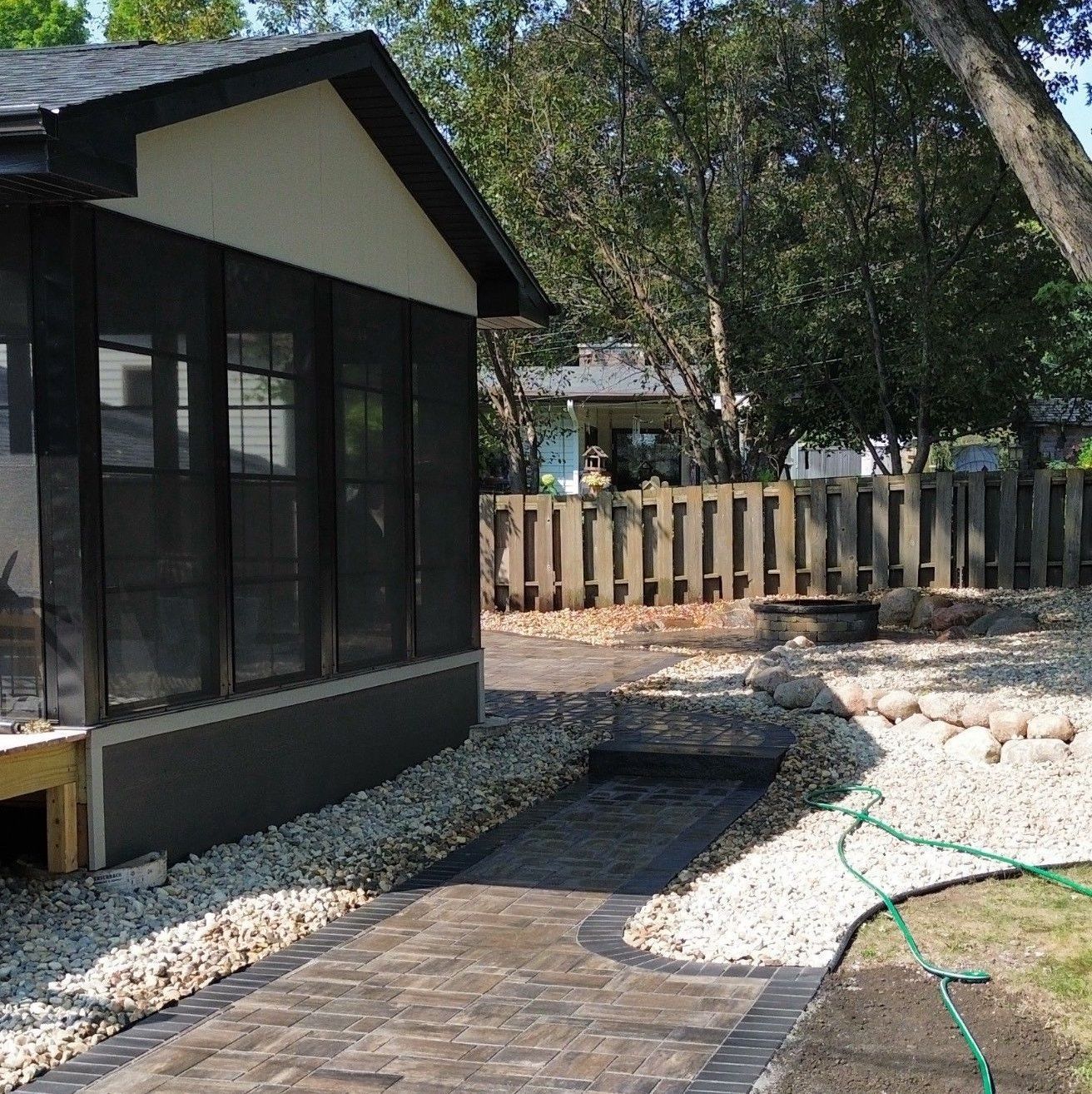 A brick walkway leads to a screened in porch