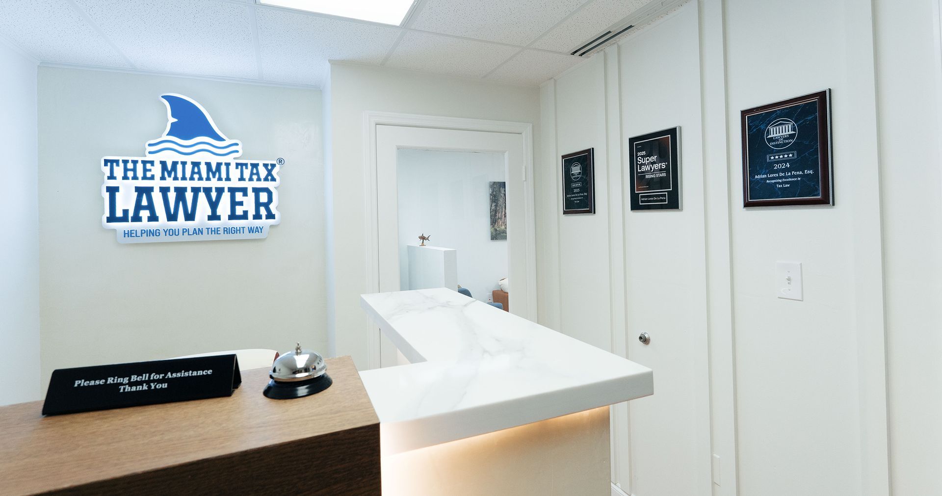 Lounge area with orange sofa, floral arrangement, wood paneling, artwork of a broken clock, and a sign.