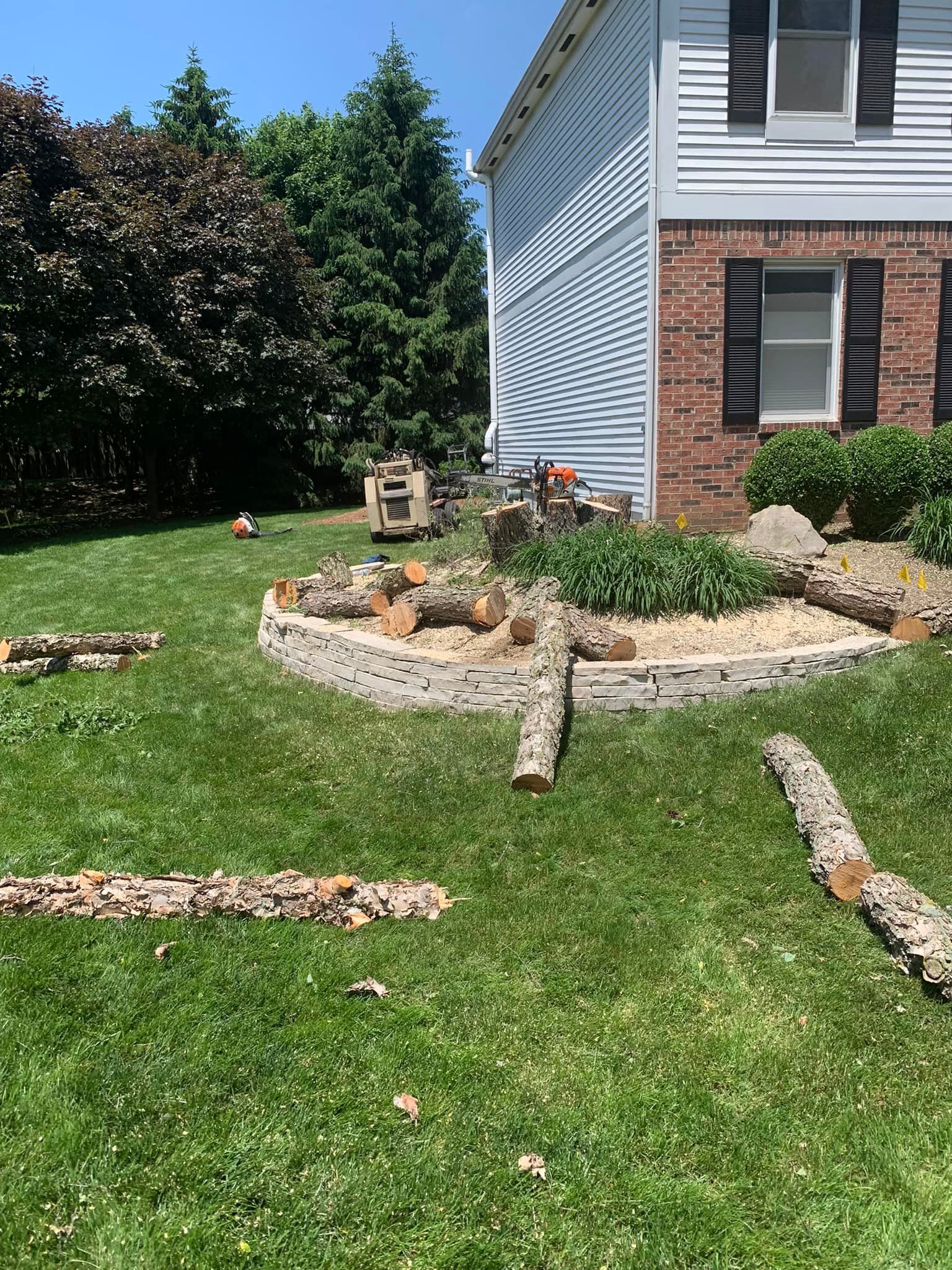 A house with a lot of logs in front of it.