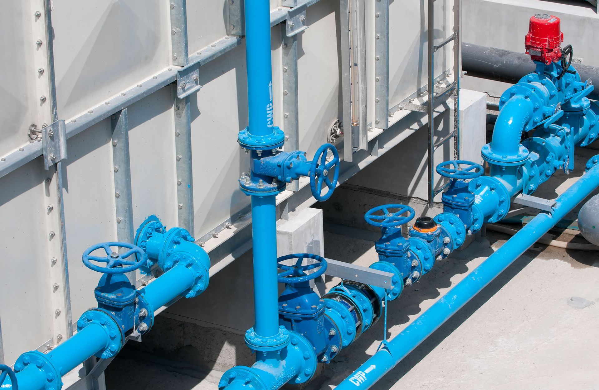 Blue pipes and valves connected to a wall