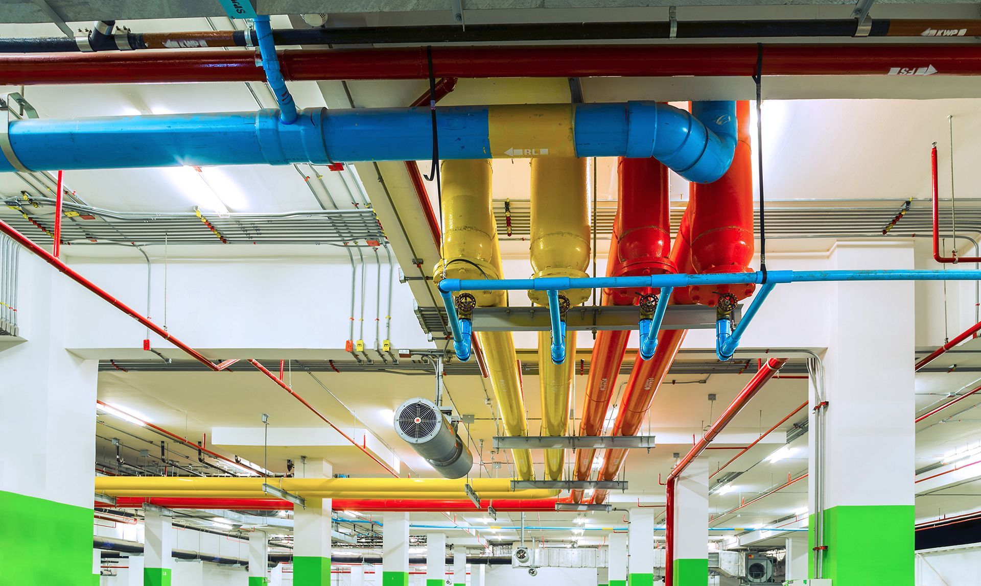 A bunch of pipes are hanging from the ceiling of a building