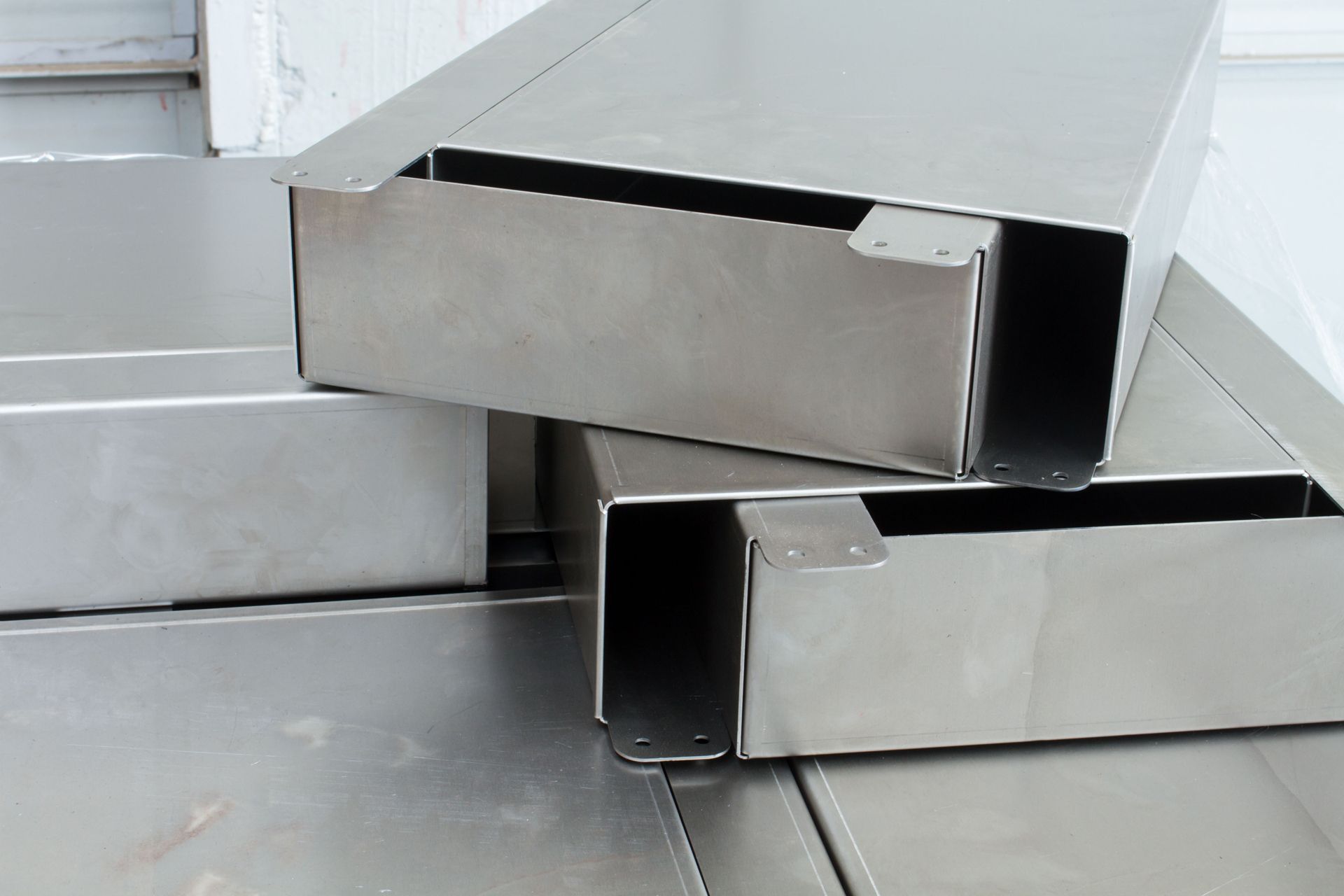 Stacked silver metal beams with hollow ends on a white background