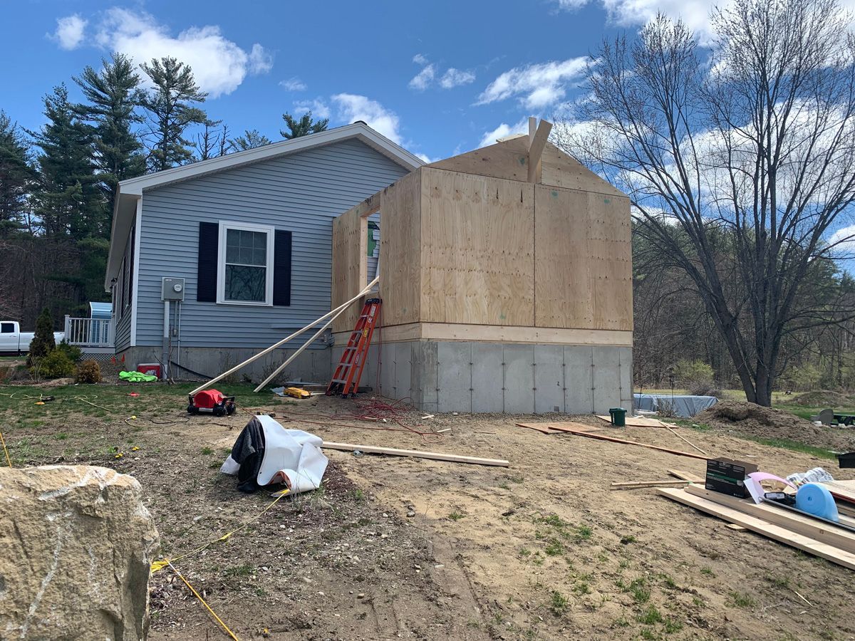 A house is being remodeled with a shed being built in the backyard.