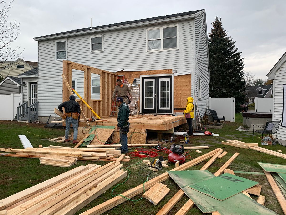 A group of construction workers are working on a house.