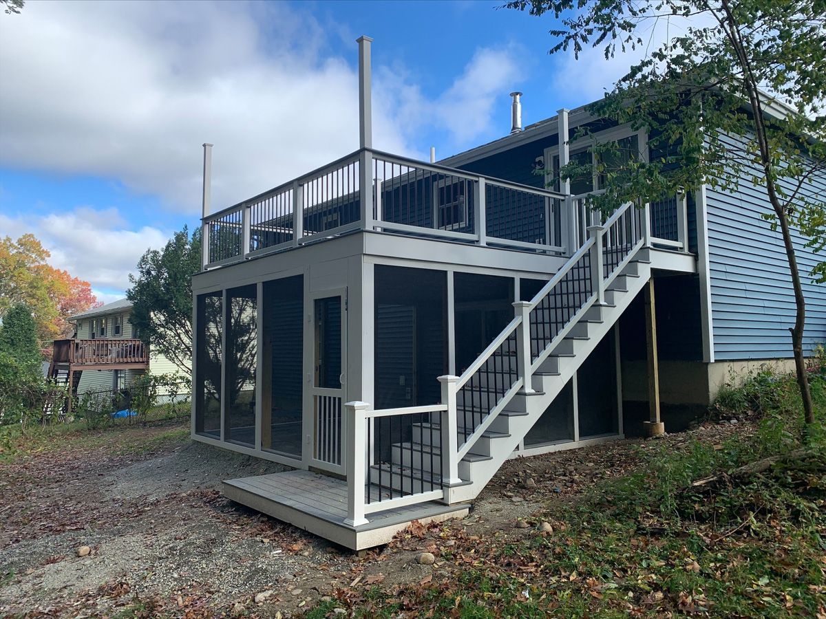 There is a screened in porch with stairs leading up to it.