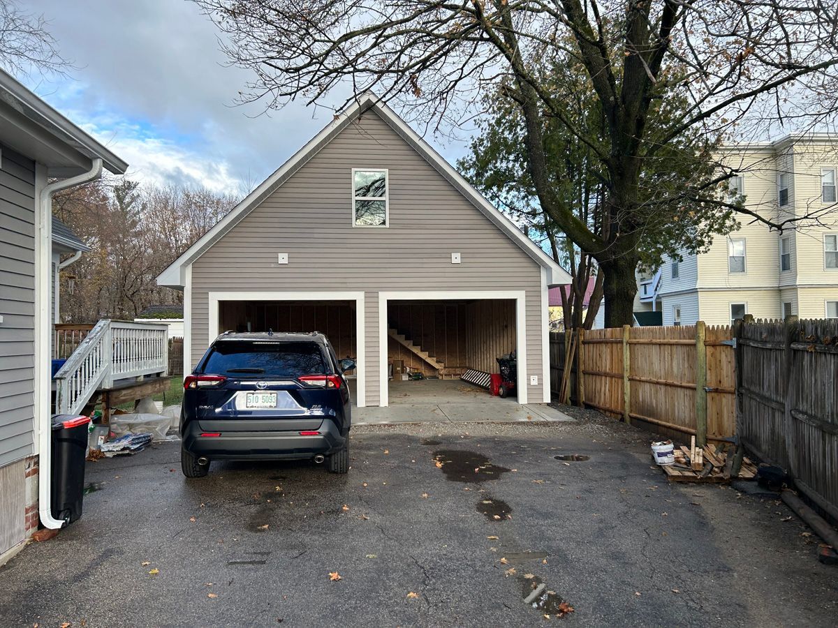 A car is parked in a garage next to a house.