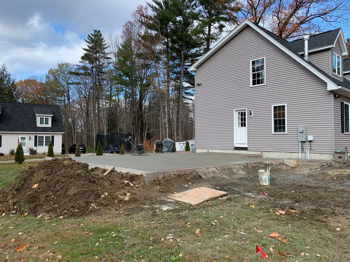 There is a large pile of dirt in front of a house.