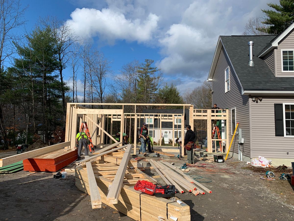 A group of construction workers are working on a house under construction.