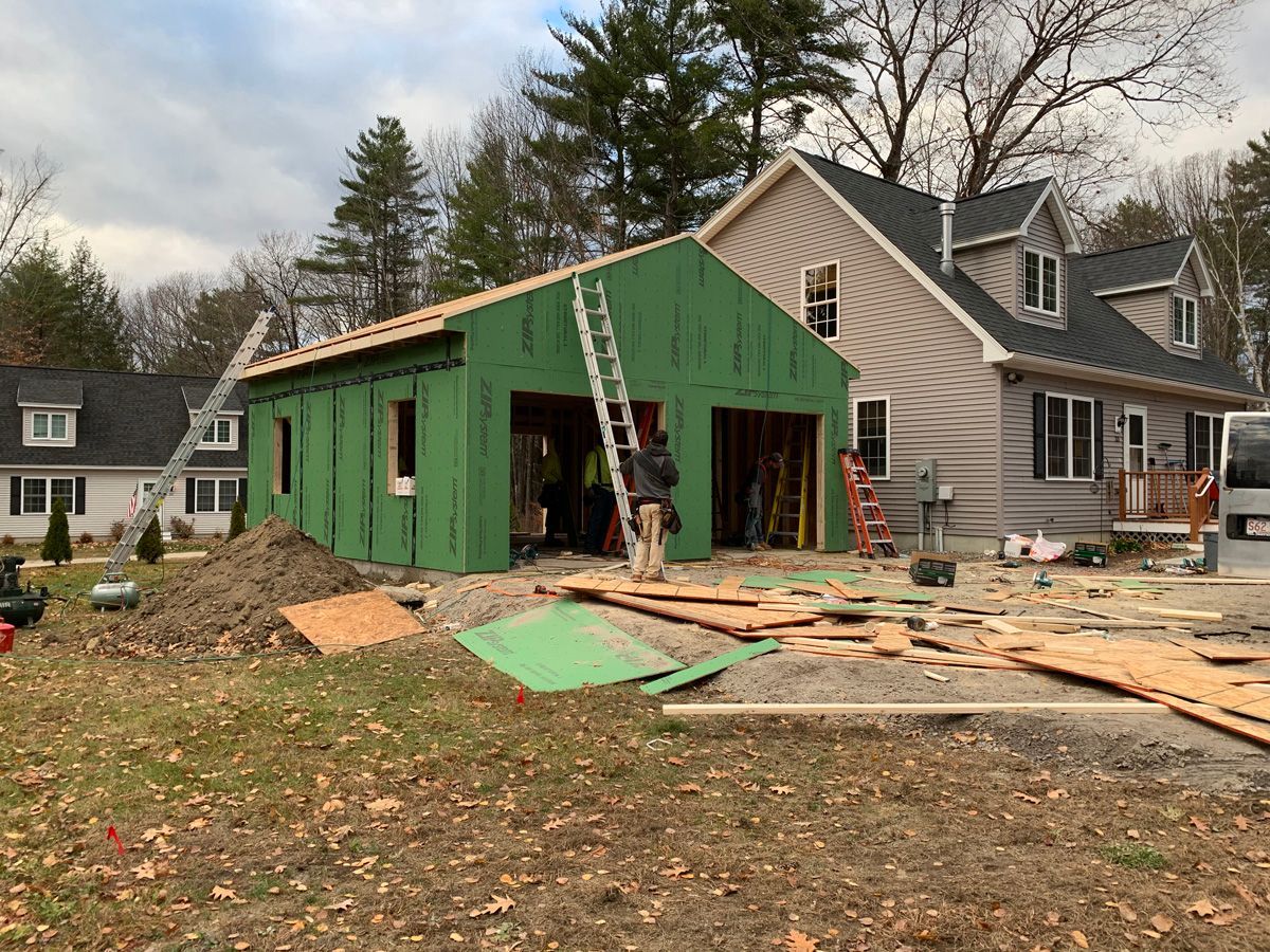 A garage is being built in front of a house.