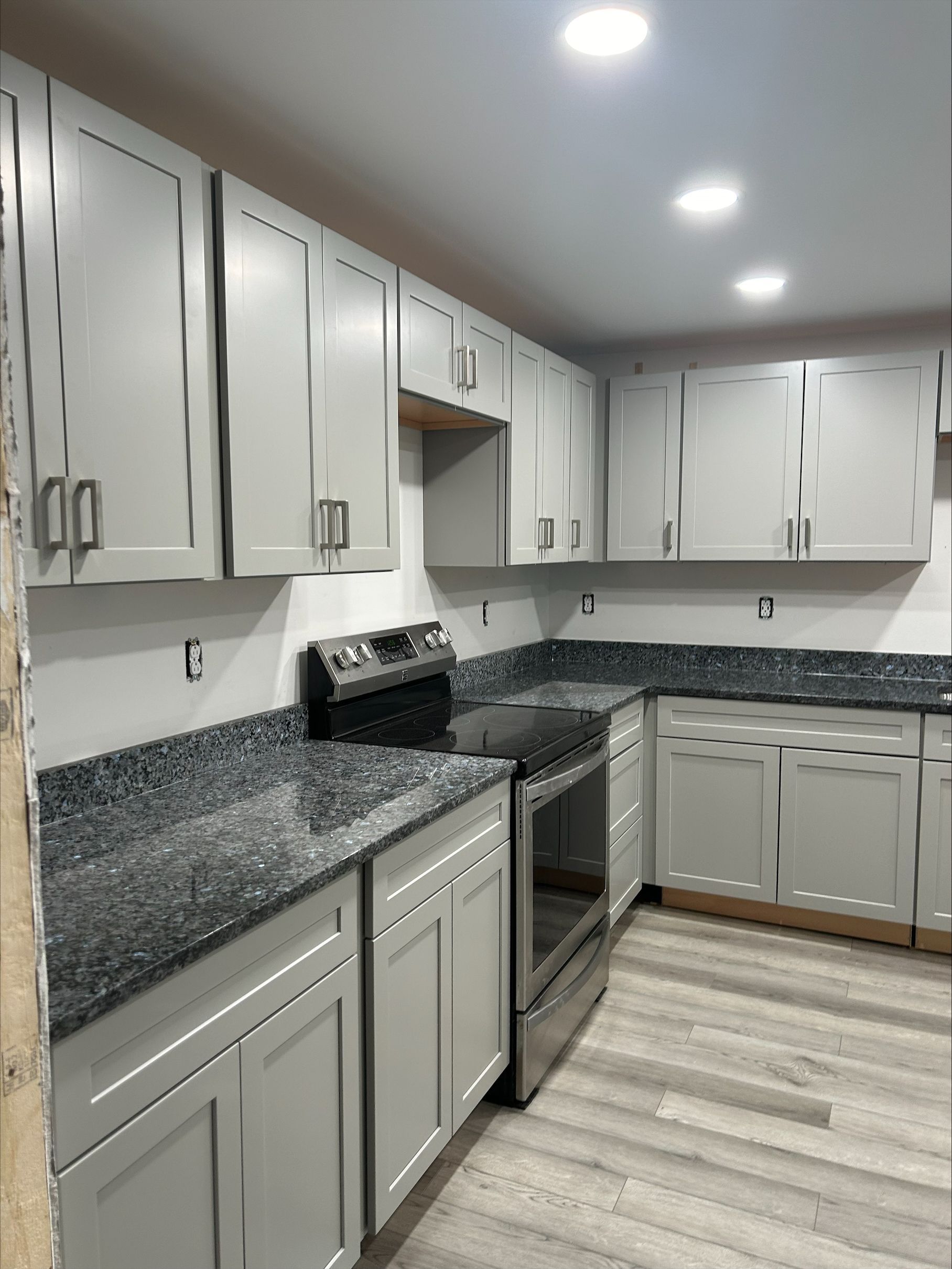 A kitchen with white cabinets and granite counter tops