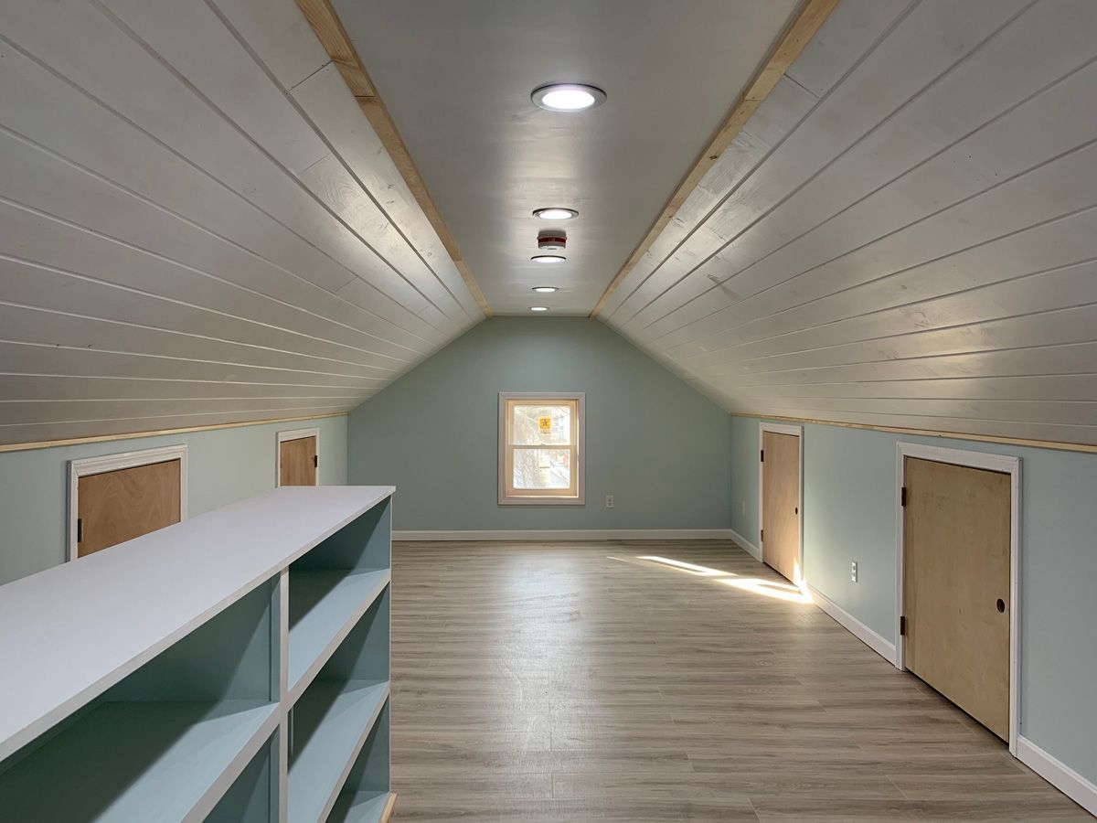 An empty attic with shelves and a window