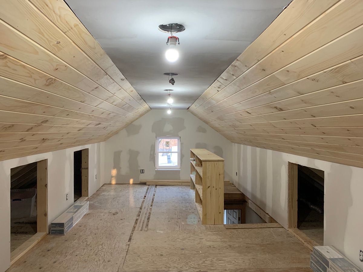 An attic with a wooden ceiling and a window