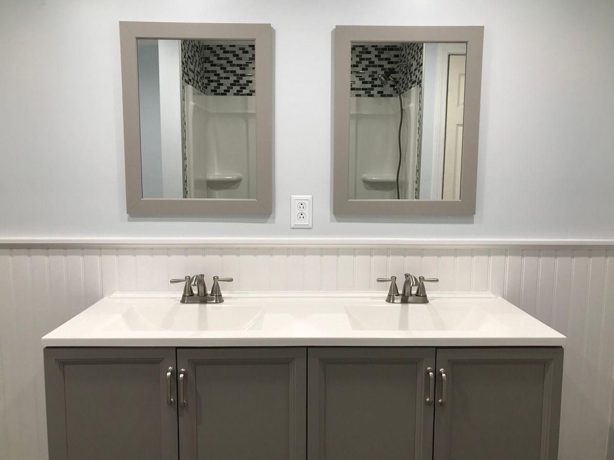A bathroom with two sinks and two mirrors.