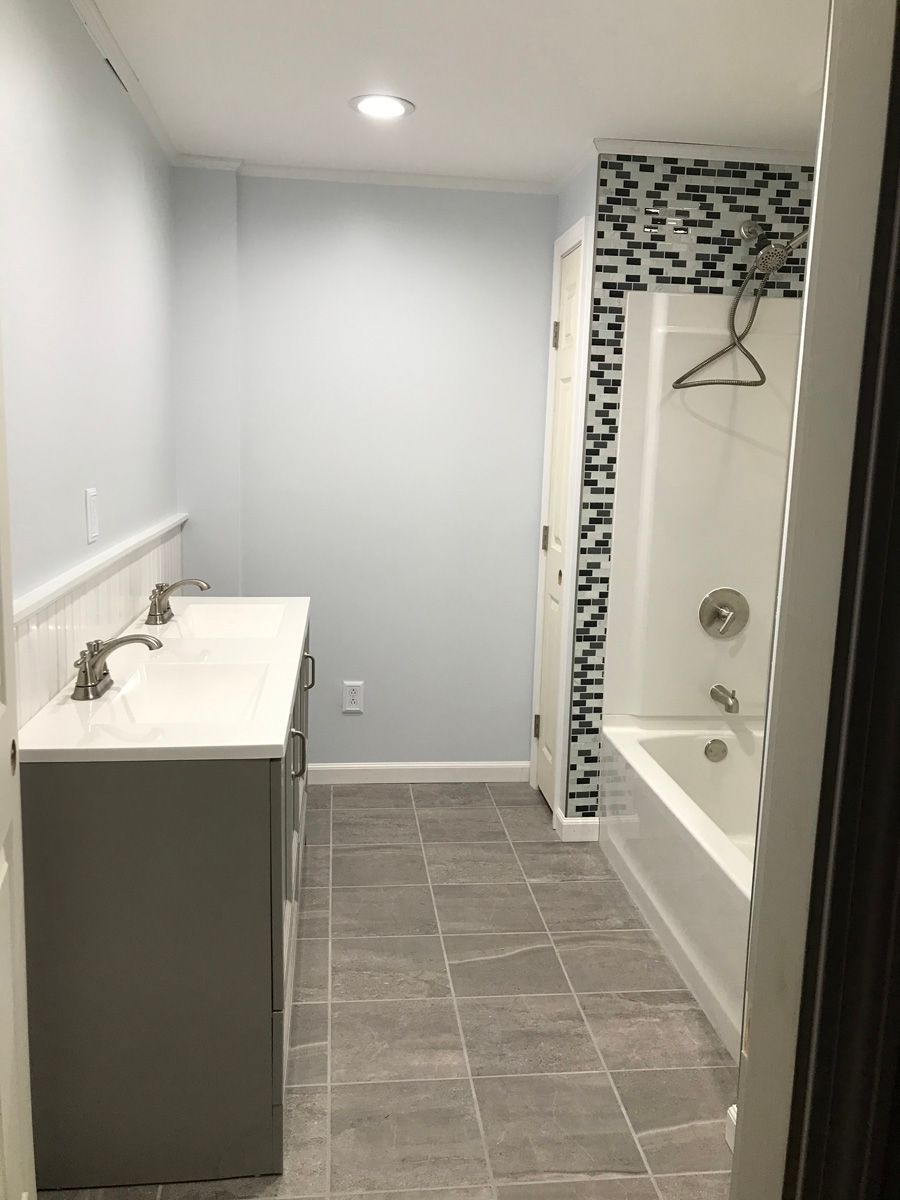 A bathroom with two sinks , a tub and a shower.
