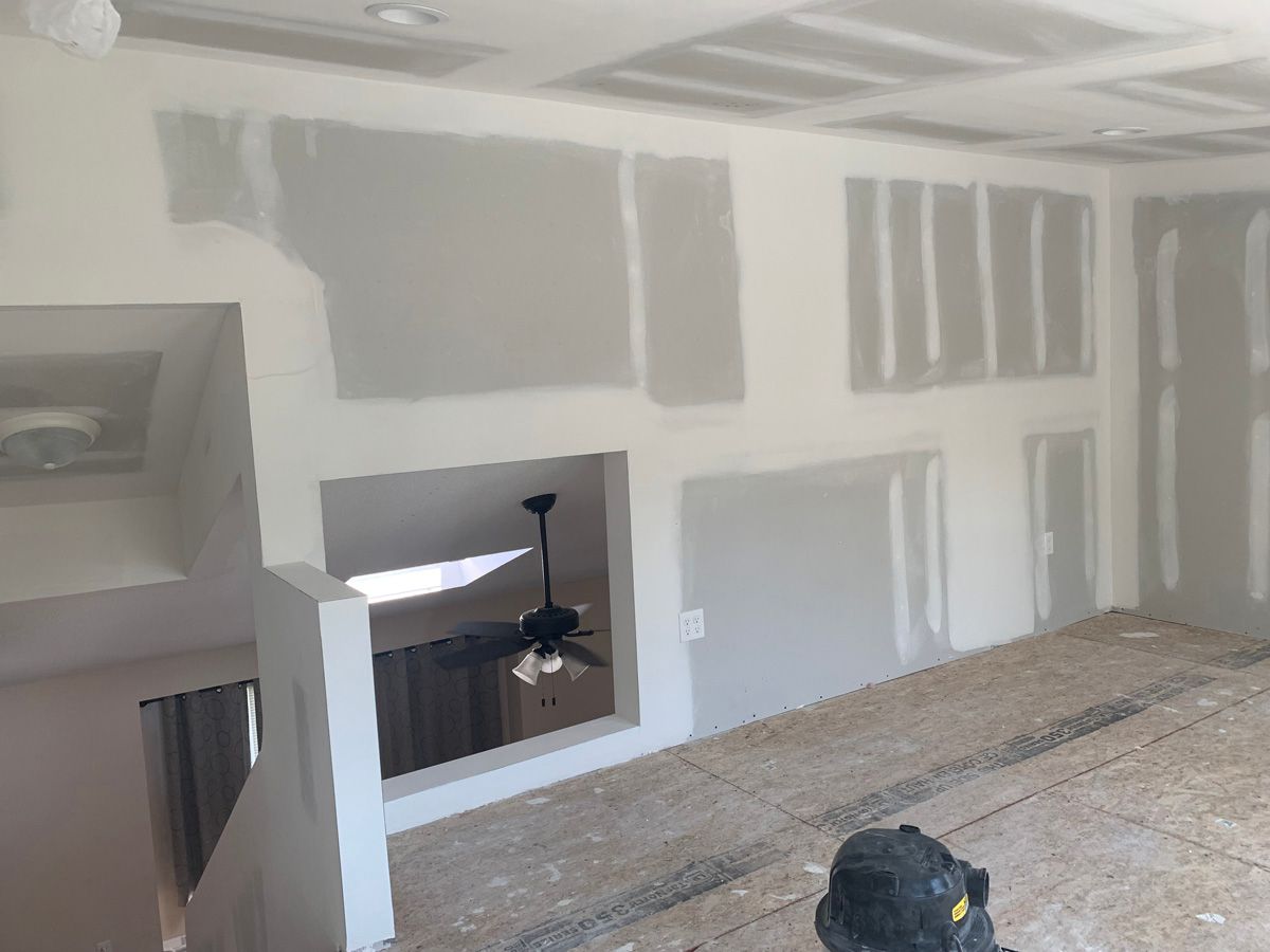 A room with a ceiling fan and a vacuum cleaner in it.