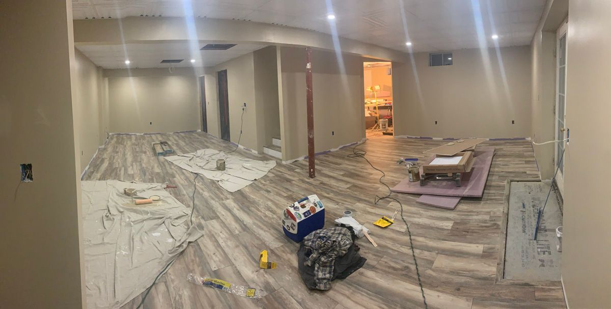 A large room with hardwood floors and a lot of tools on the floor.