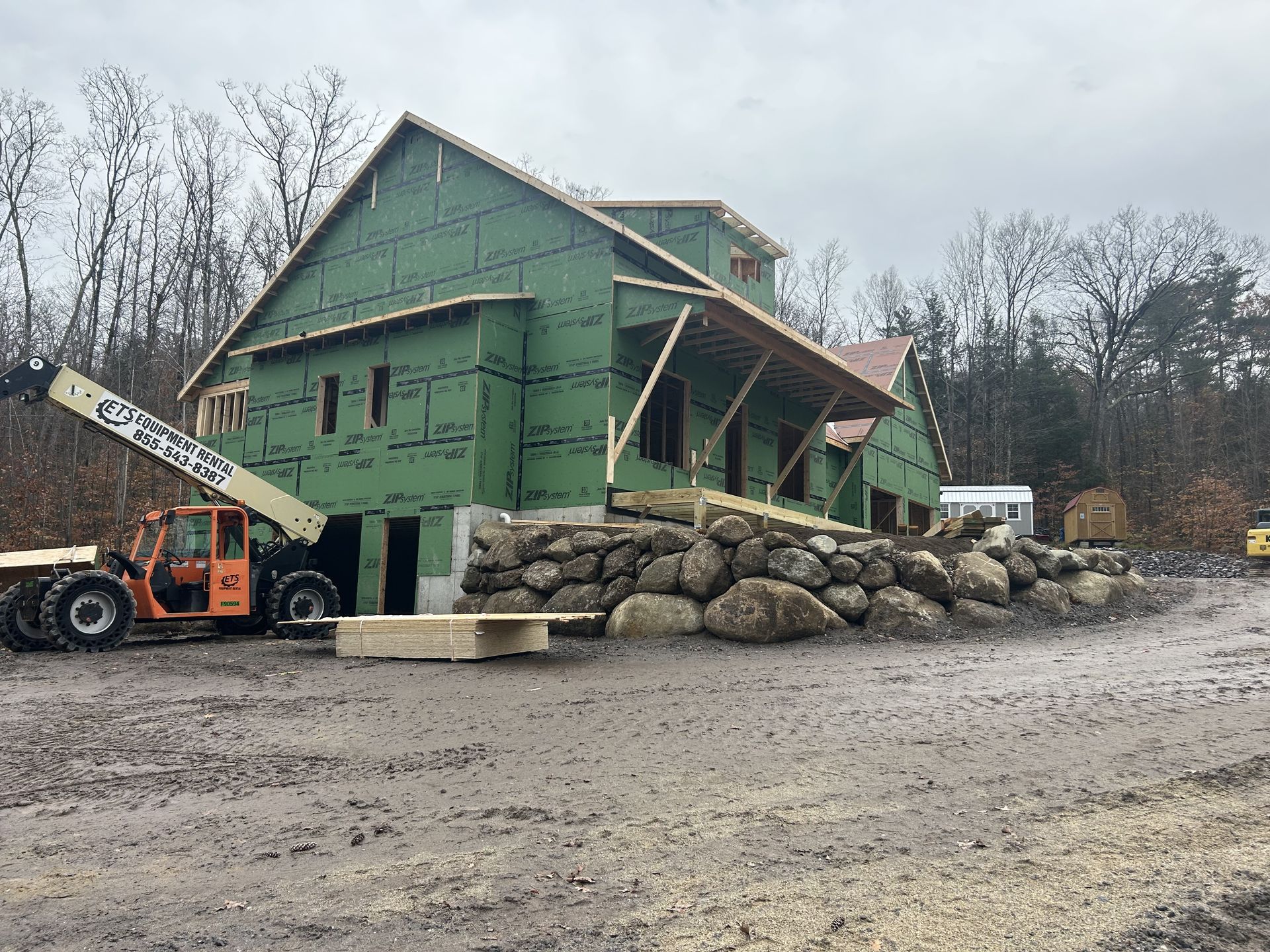 A large house is being built in a dirt field.