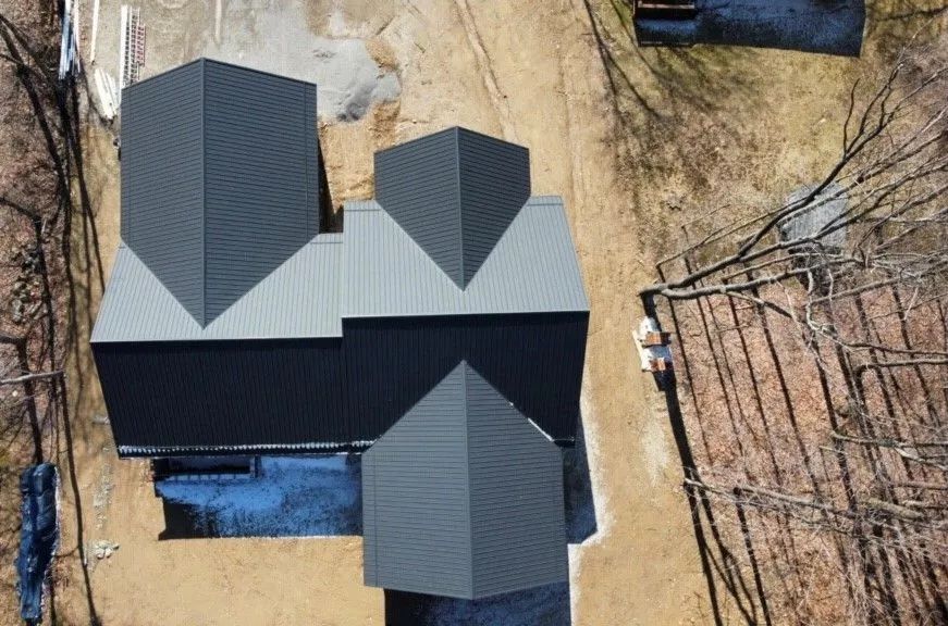 An aerial view of a house under construction with a black roof.