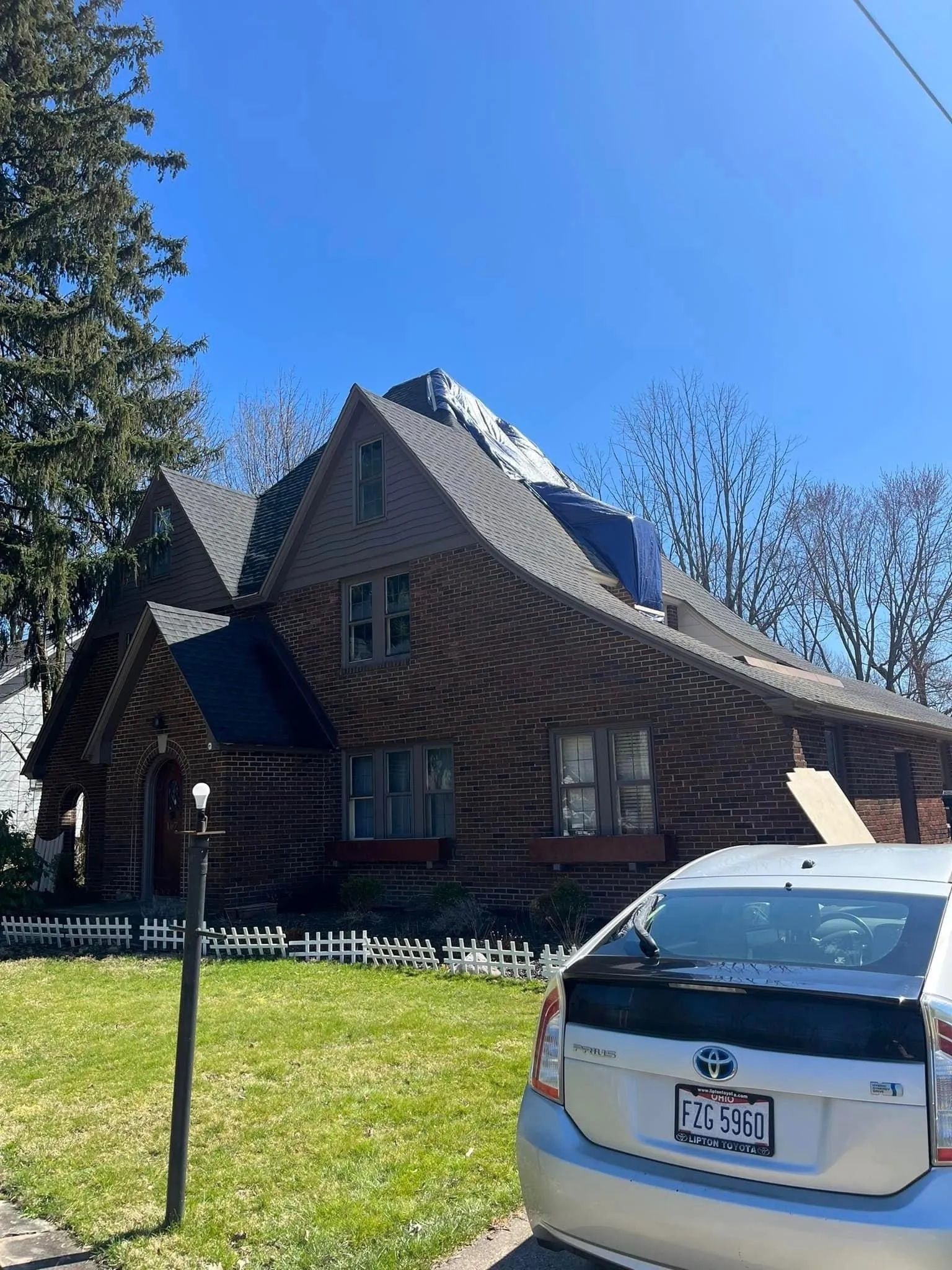 A car is parked in front of a log cabin.