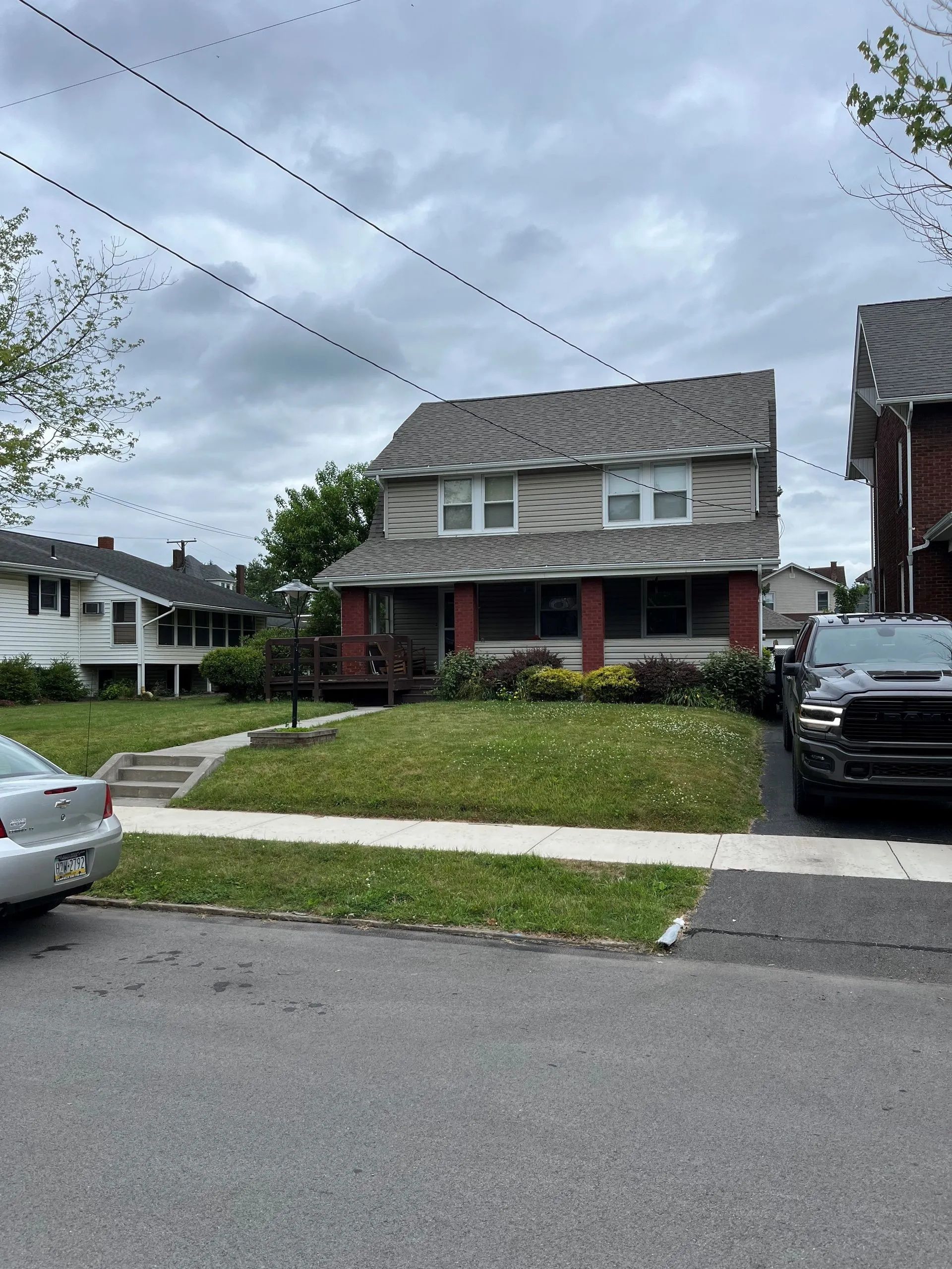 A couple of cars are parked in front of a house.